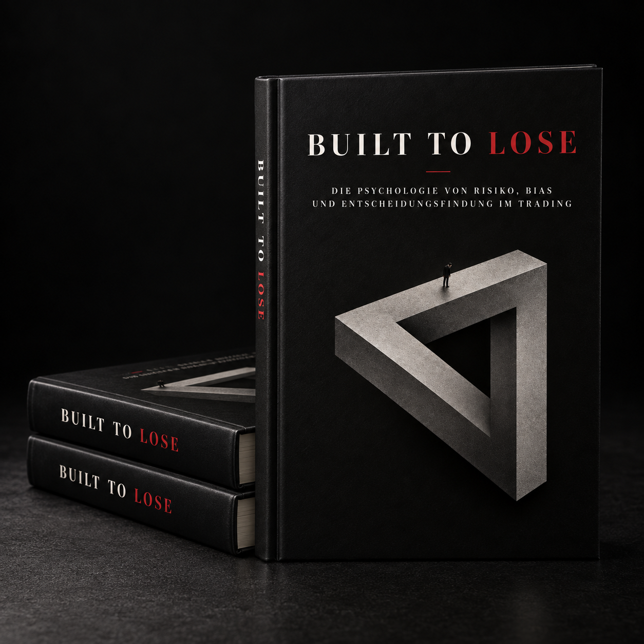 Built to Lose hardcover with the German subtitle, a stone triangle and a lone figure on its cover, next to two stacked copies.